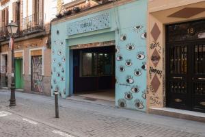 a blue building with eyes on the side of a street at Malasaña Boutique in Madrid