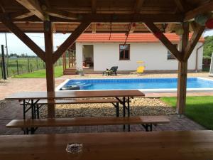 a picnic table in front of a swimming pool at Termálvölgye Vendégház in Demjén