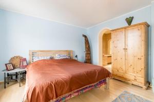 a bedroom with a large bed and a wooden cabinet at Private Room in Hannover