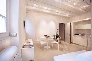 a white apartment with a table and chairs in a room at Le Nuove Cadreghe Apartments in Verona