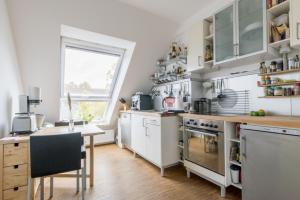 ハノーファーにあるPrivate Roomの白い家電製品、テーブル、窓が備わります。