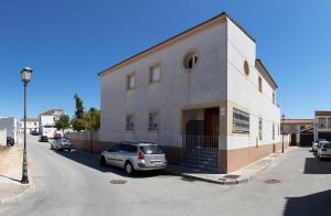 Villanueva del AriscalにあるVilla Grande del Aljarafeの路上の建物の前に駐車された車