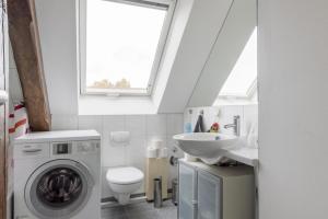 ハノーファーにあるPrivate Roomの洗濯機と洗面台を備えたバスルーム
