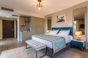a bedroom with a large bed with a blue headboard at Karia Hotel Palamutbükü in Cumalı