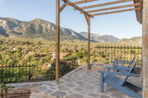 a blue chair on a patio with mountains in the background at Karia Hotel Palamutbükü in Cumalı