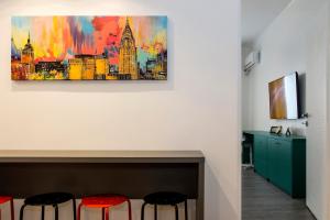 een kamer met twee krukken en een schilderij aan de muur bij Premium Apartment by MRG Apartments in Boekarest