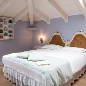 Villa Belverde Boutique Hotel في كارارا: غرفة نوم بسرير ابيض كبير مع شراشف بيضاء