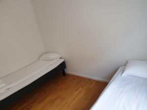 a small bedroom with a bed and a wooden floor at Zemfira AB, Visby Innerstad in Visby