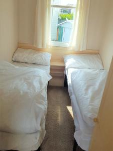 two beds in a small room with a window at 6 Berth with private Garden - 69 Brightholme Holiday Park Brean! in Brean
