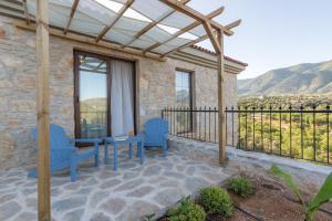 a patio with two blue chairs and a pergola at Karia Hotel Palamutbükü in Cumalı
