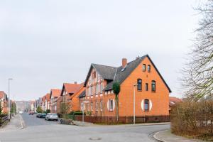 a large orange brick house with a black roof at Private Rooms in Hannover