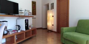 a living room with a green couch and a television at Maria Carolina Casavacanze in Caserta