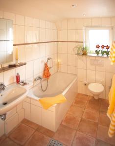 a bathroom with a tub and a sink and a toilet at Hotel Hirsch mit Café Klösterle in Enzklösterle