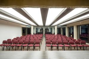 an empty auditorium with red chairs in a building at Zámek Lužec Spa & Wellness Resort in Karlovy Vary