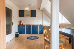 a kitchen with blue cabinets and a dining table at Private Apartment in Hannover