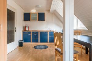 ハノーファーにあるPrivate Apartmentのキッチン(青いキャビネット、ダイニングテーブル付)