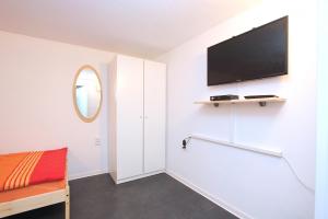 ハノーファーにあるPrivat-Souterrain-Apartmentのベッドルーム(ベッド1台、薄型テレビ付)