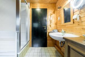 a bathroom with a black door and a sink at Apartment am Bullerbach Deister in Barsinghausen