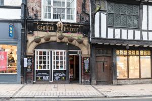 uma loja com uma placa na frente de um edifício em Golden Fleece York em York