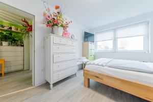 a bedroom with a bed and a dresser with flowers on it at Private Room Laatzen in Hannover