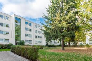an apartment building with a tree in front of it at Privatapartment Messe Süd in Hannover