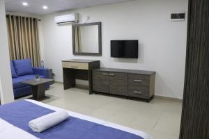 a hotel room with a bed and a tv at The Cate House in Lagos