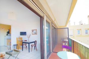 a room with a balcony with a table and chairs at Studio moderne à la plage in Canet-en-Roussillon