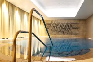una piscina con escalera en un edificio en SEETELHOTEL Strandhotel Atlantic en Bansin