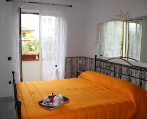een slaapkamer met een oranje bed en een dienblad bij Libro di Sogni - B&B Letterario in Casertavecchia