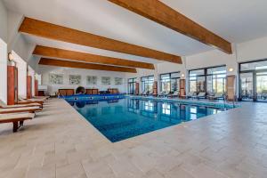 a swimming pool in a building with windows at Club Insieme Grand Resort in Potlogi
