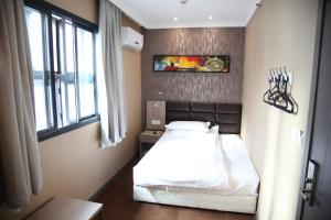 a bedroom with a white bed and white walls at Shanghai Fish Inn Bund in Shanghai