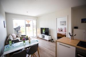 a living room with a dining table and a living room at Strandchalet Elmo I in Wremen in Wremen