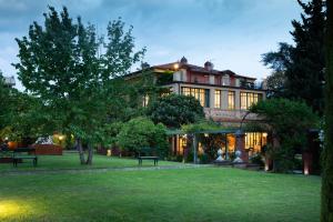 a large building with a lawn in front of it at Villa Belverde Boutique Hotel in Carrara