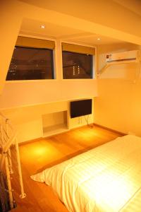 a bedroom with a bed and a flat screen tv at Shanghai Fish Inn East Nanjing Road in Shanghai