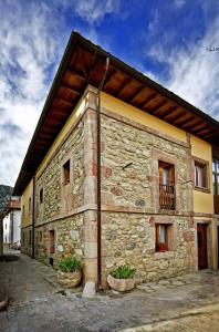 a stone building with two potted plants in front of it at El Camino Real II * in Poo de Cabrales