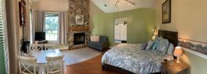 Rock Pointe Ranch في Floral City: غرفة نوم مع سرير وغرفة معيشة مع موقد