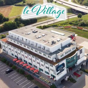 duży biały budynek ze słowami la village na nim w obiekcie Hotel Le Village w mieście Winnenden