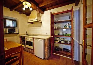 a kitchen with a refrigerator and a stove top oven at El Camino Real II * in Poo de Cabrales