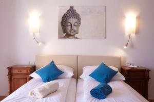 een slaapkamer met 2 bedden met blauwe kussens en een standbeeld bij Finca Son Manera in Montuiri