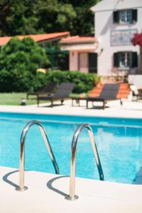a swimming pool with a pair of tongs on a table next to a pool at Quinta Verde Sintra - Casa de Campo in Sintra