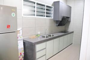 a small kitchen with a sink and a refrigerator at BELLE VILLE in Muar