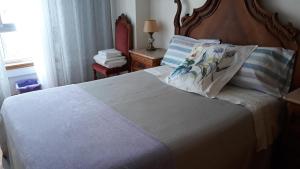 a bedroom with a large bed with a wooden headboard at Apartment in Portela near the Airport in Lisbon +2 photos