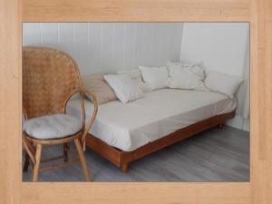 a bed and a chair in a room with a chair at LES HORTENSIAS in Sainte-Marie-aux-Mines