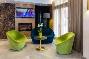 a living room with two green chairs and a table at Venice Maggior Consiglio in Venice