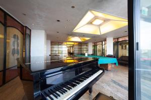 a room with a piano and two ping pong tables at Hotel Diplomat Palace in Rimini