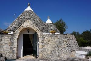 a stone building with a door and a stone wall at Trullo Ada in Ceglie Messapica