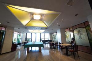 a dining room with a green table and chairs at Hotel Diplomat Palace in Rimini