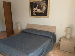 a bedroom with a bed and a picture on the wall at La Casa di Zoe - Terre del Magra in Bocca di Magra