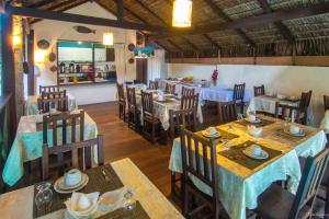 een eetkamer met tafels en stoelen en een restaurant bij Pousada La Cigale in Paraty
