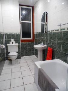 a bathroom with a tub and a toilet and a sink at 4 Bed Apartment, Paisley - Near GLA Airport in Paisley